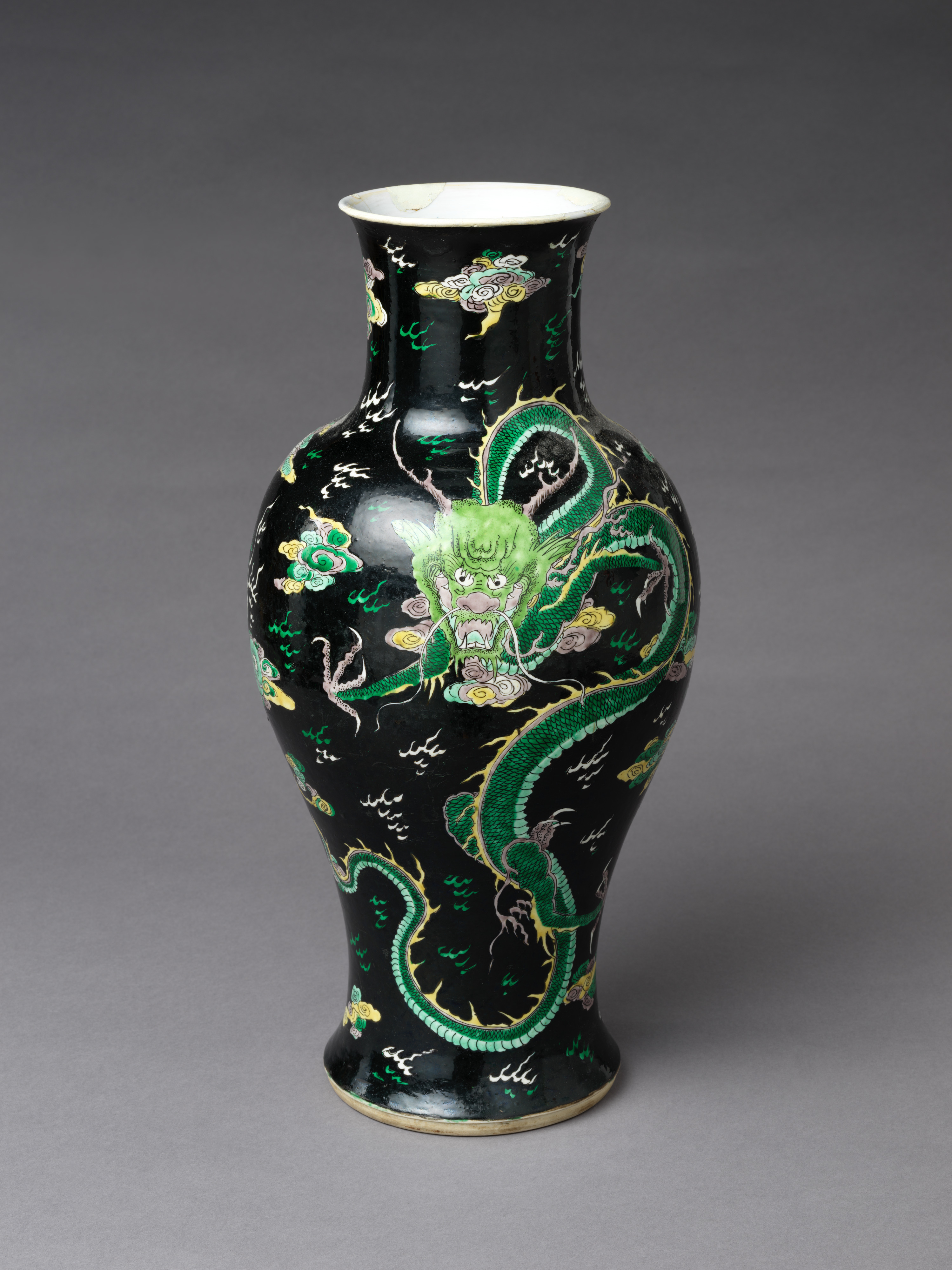 A Qing-dynasty vase with polychrome dragon decoration on a black ground, famille-noire ware.
