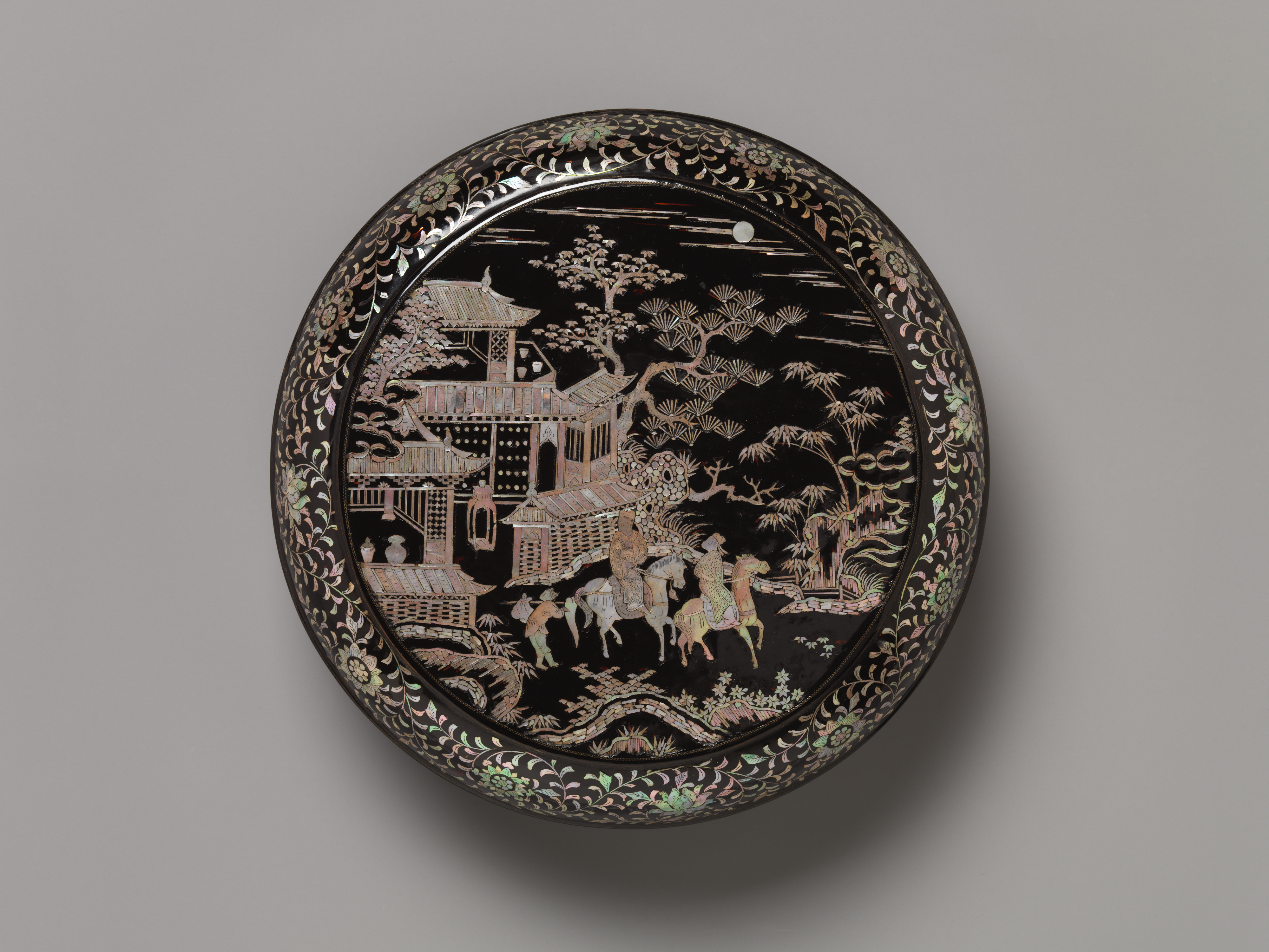 Boîte ronde chinoise en laque noire, décor figuratif en nacre incrustée représentant un pavillon, des arbres et des cavaliers.