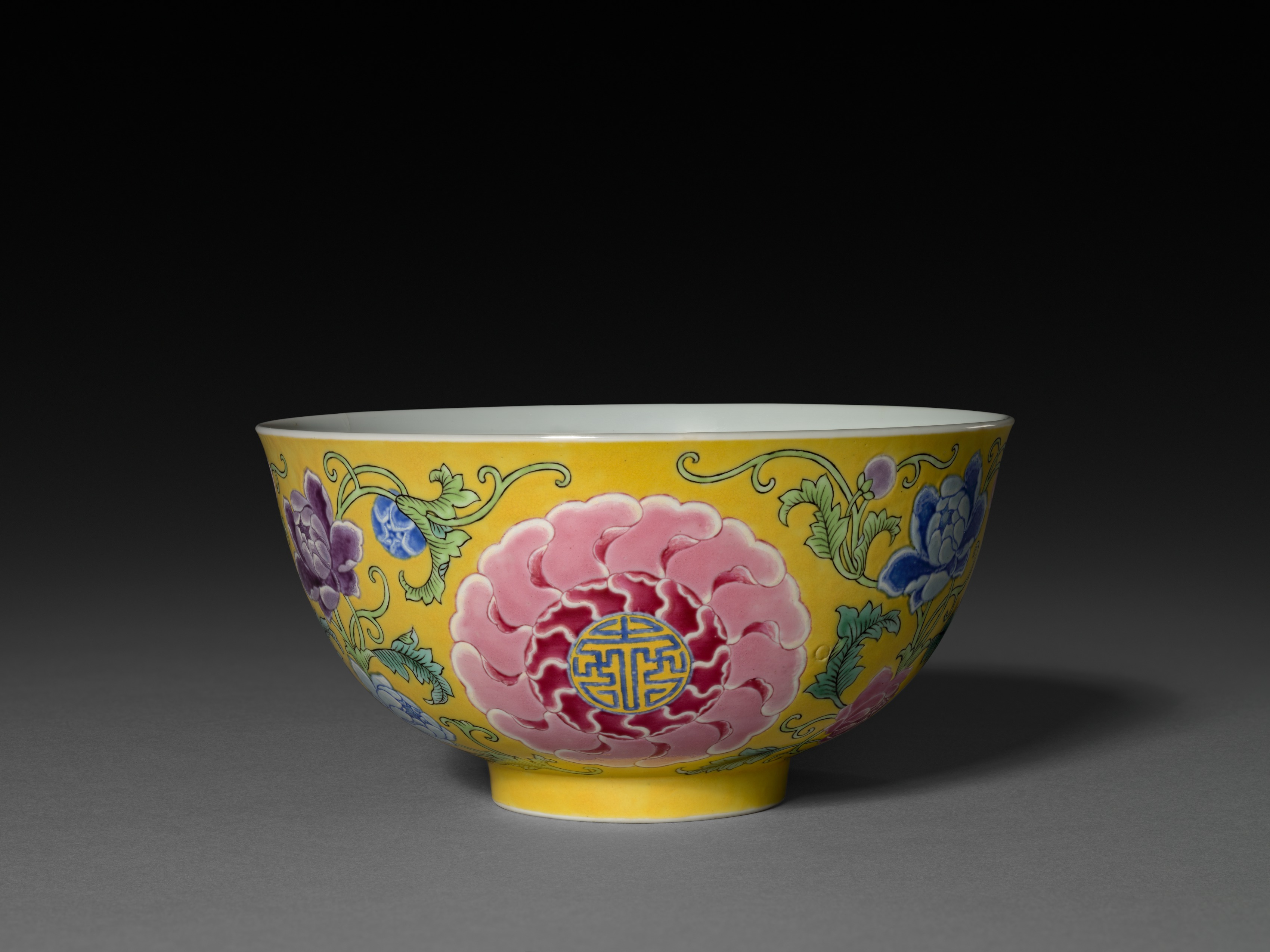 Bol en porcelaine chinoise à émaux famille rose sur fond jaune, médaillons réservés contenant des caractères, entourés de pivoines.