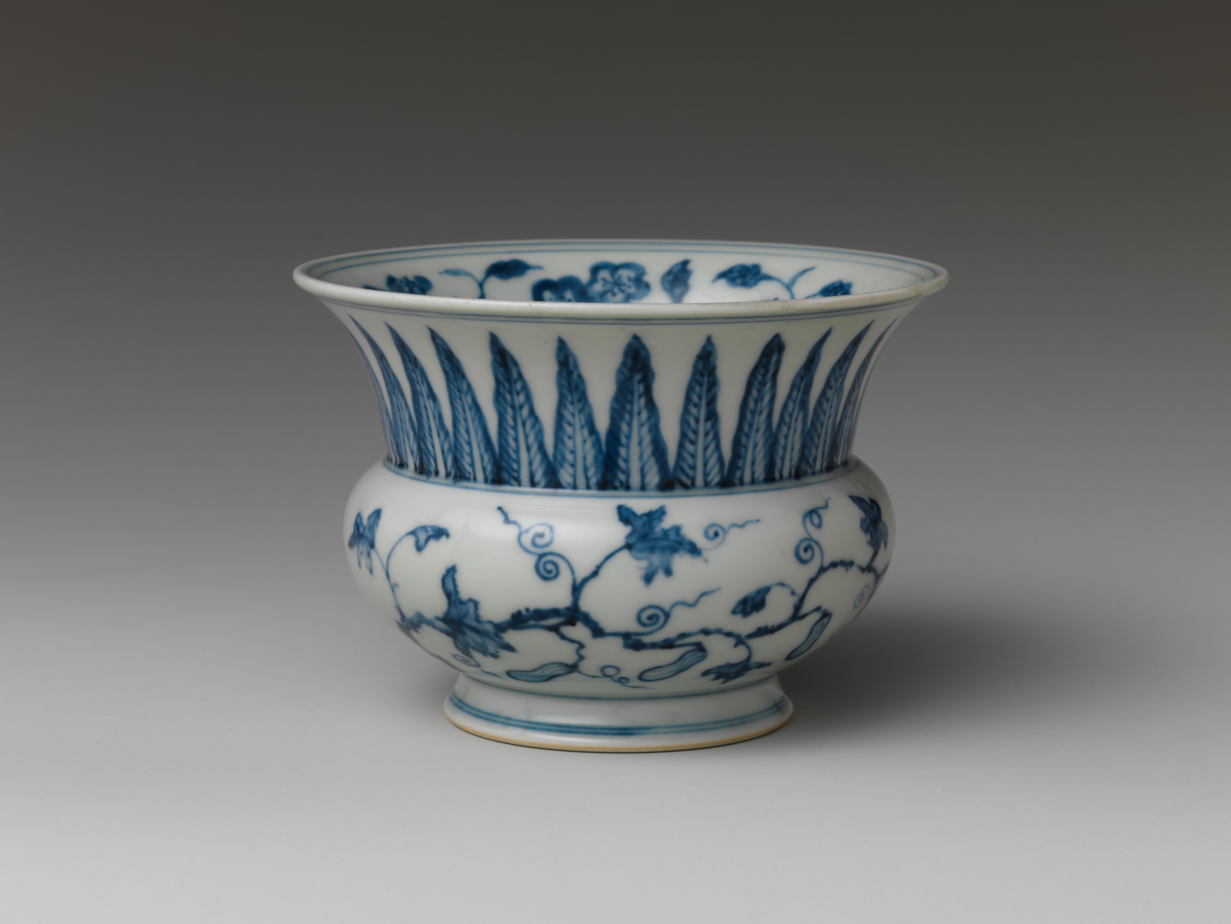 Récipient à large col évasé en porcelaine bleu et blanc, décor de rinceaux et de gourdes.
