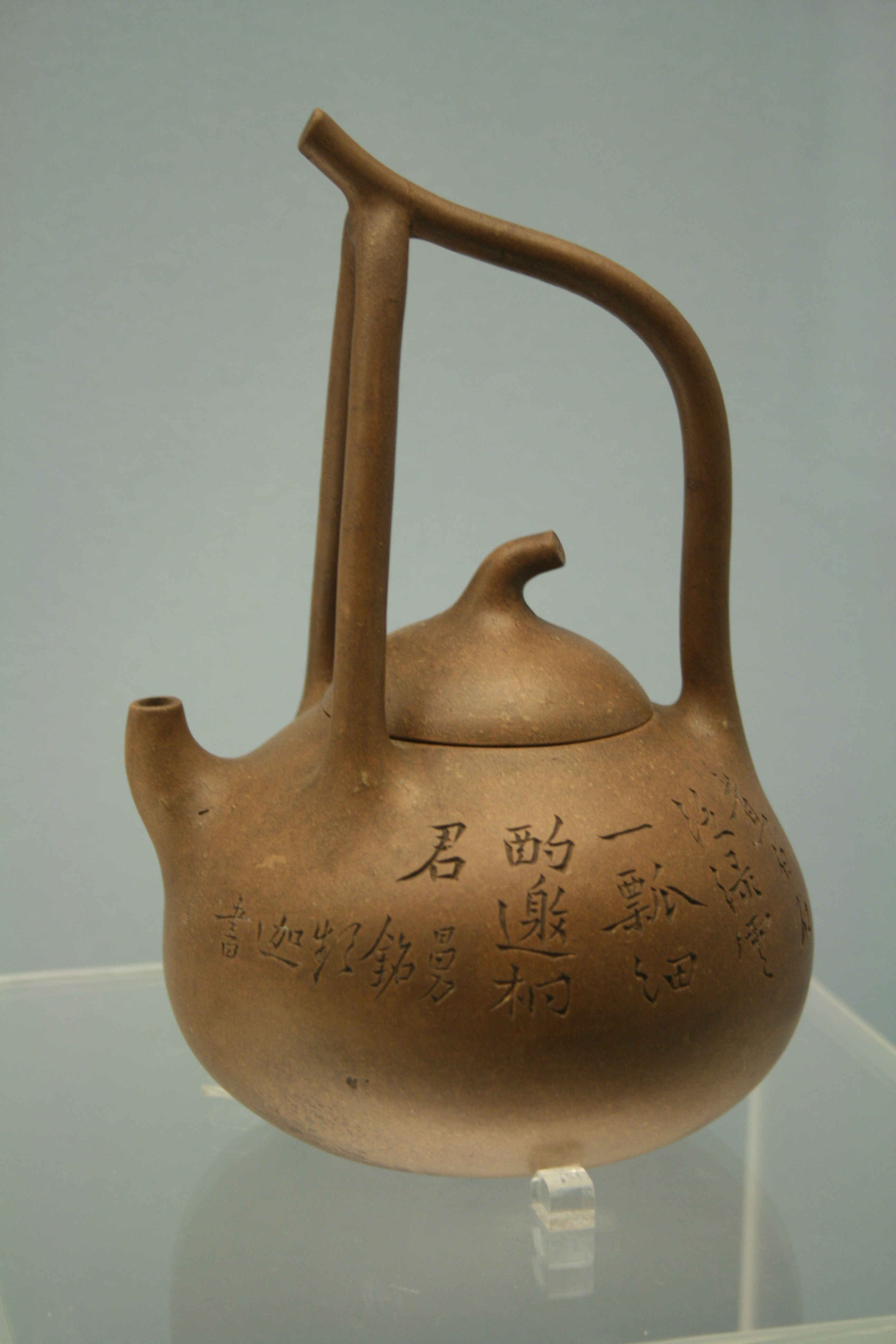 Théière Yixing à anse en pont, inscription calligraphiée gravée sur la paroi, exemplaire de l'atelier Mansheng conservé au Shanghai Museum.
