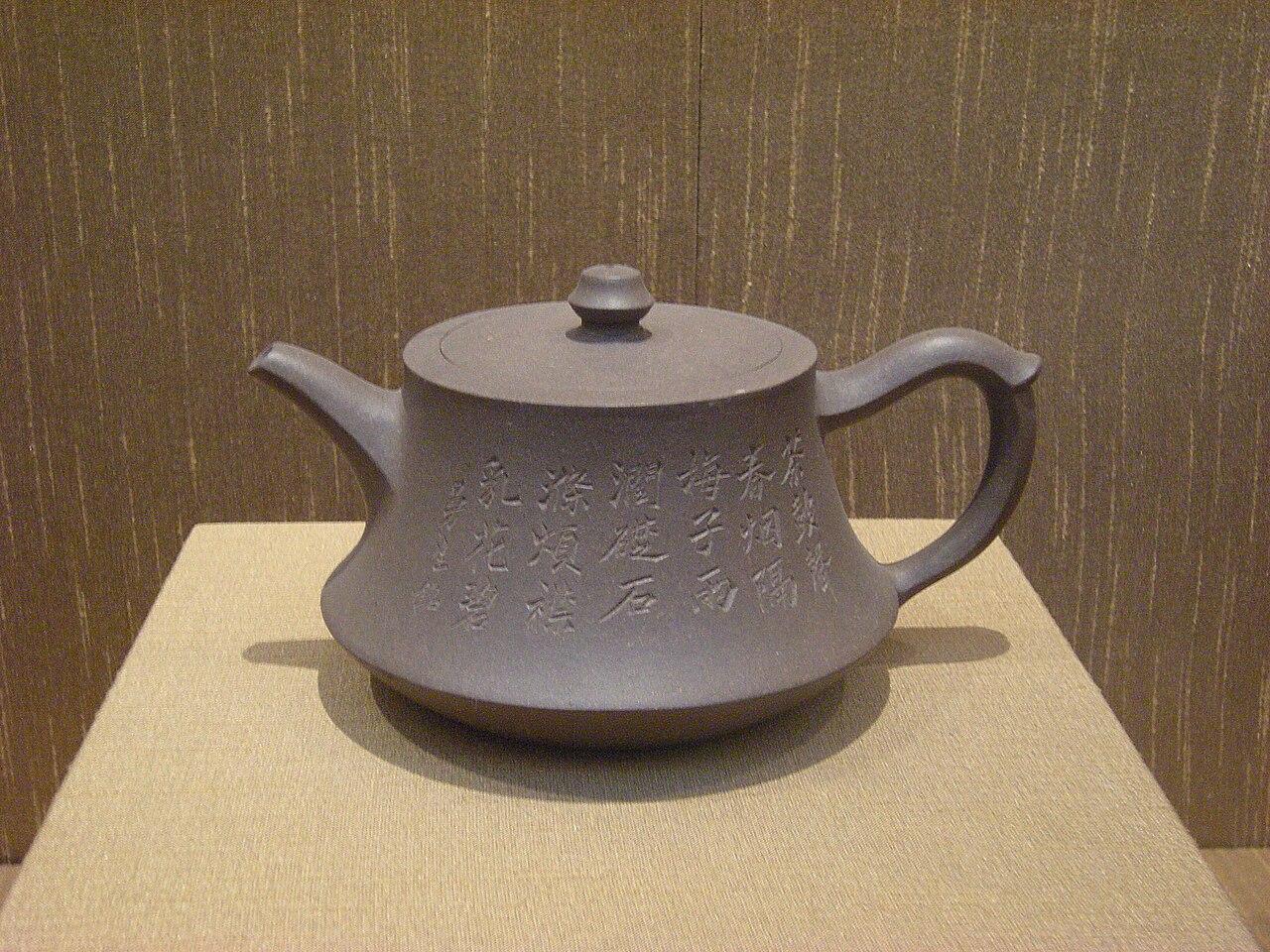 Théière Yixing de l'atelier Mansheng — grès non émaillé à inscription calligraphiée, montrant le cachet d'atelier sur le fond.